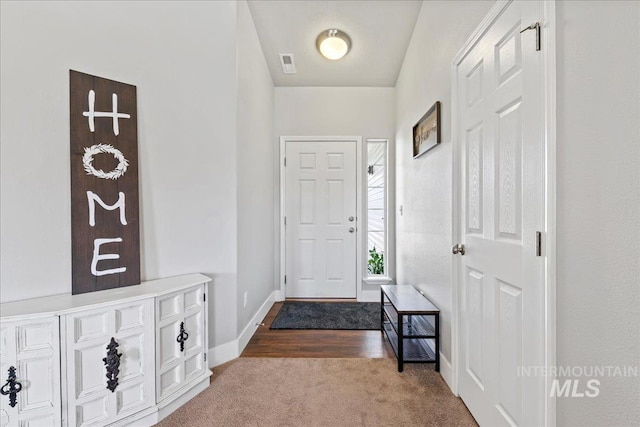 entryway featuring dark colored carpet and baseboards