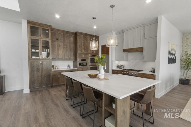 12975 Sandy Dr, Donnelly, ID 83615 - kitchen with double oven, a breakfast bar, light countertops, baseboards, and recessed lighting