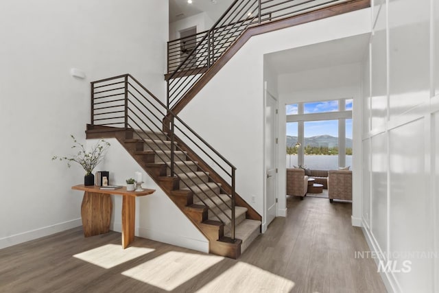 12975 Sandy Dr, Donnelly, ID 83615 - stairway with a towering ceiling, wood finished floors, baseboards, and a water view