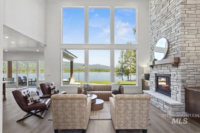 12975 Sandy Dr, Donnelly, ID 83615 - living room with a fireplace, a water view, wood finished floors, a towering ceiling, and recessed lighting