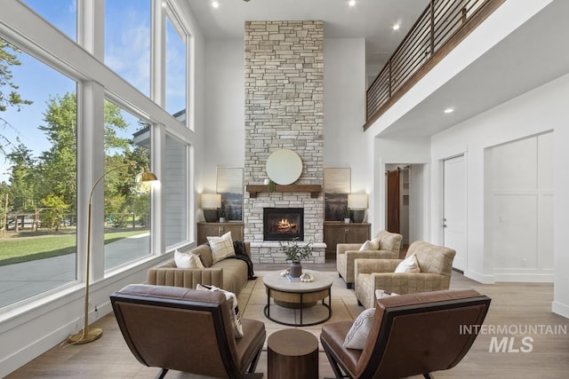 12975 Sandy Dr, Donnelly, ID 83615 - living area with a high ceiling, healthy amount of natural light, a fireplace, light wood-type flooring, and baseboards
