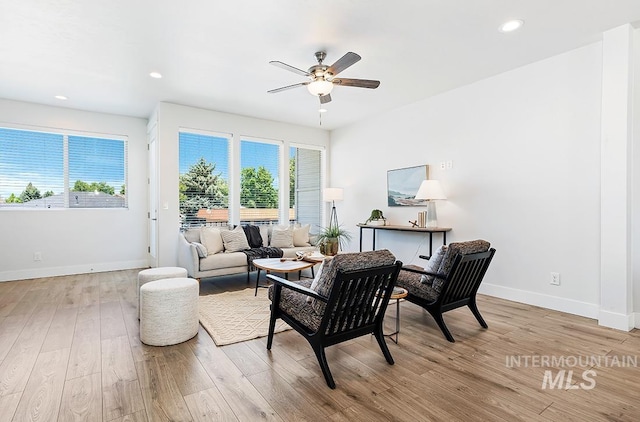 living room with light wood-type flooring, plenty of natural light, and ceiling fan