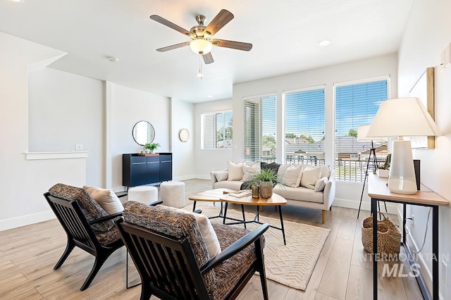 living room with ceiling fan, light hardwood / wood-style floors, and plenty of natural light