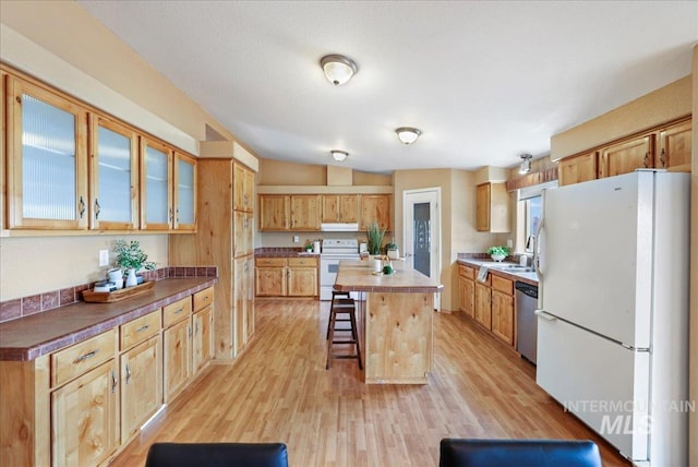 4240 N 1400 E, Buhl, ID 83316 - kitchen featuring white appliances, a breakfast bar area, light wood-type flooring, a kitchen island, and glass insert cabinets