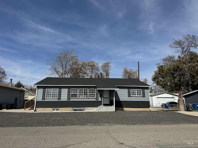 view of front of home with an outbuilding, a garage, and a shingled roof