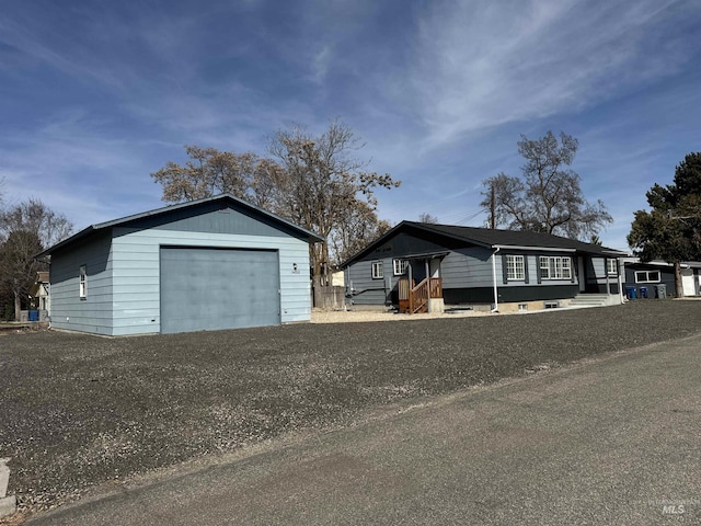 view of front facade with a detached garage and an outbuilding