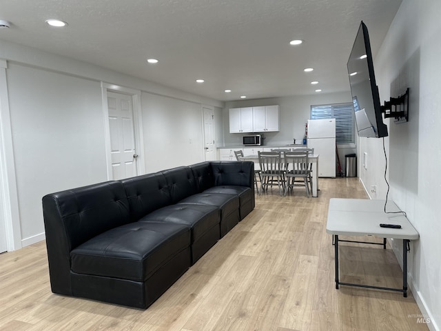 living room with light wood-style flooring, recessed lighting, and baseboards