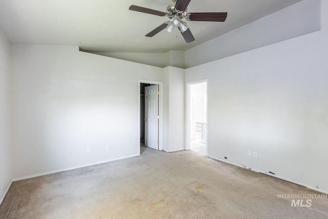 spare room featuring carpet floors, a ceiling fan, lofted ceiling, and baseboards