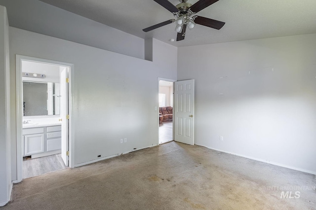 unfurnished bedroom with carpet floors, baseboards, a sink, and connected bathroom