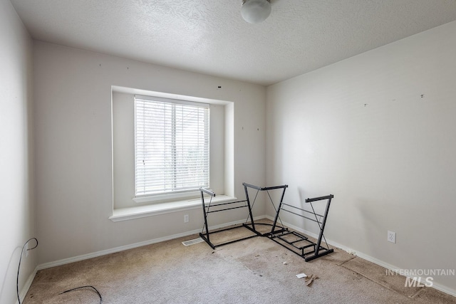 interior space with baseboards, carpet flooring, and a textured ceiling