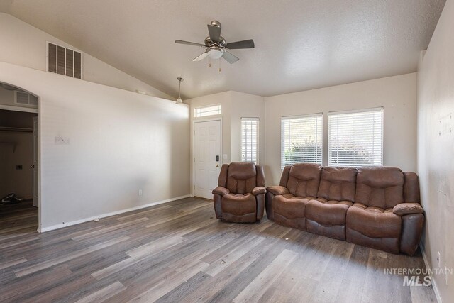 living area featuring plenty of natural light, wood finished floors, visible vents, and ceiling fan