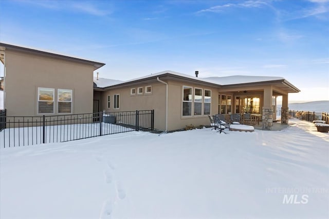 snow covered house with central air condition unit