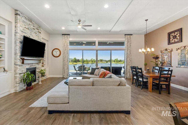 547 S Rivermist Ave, Star, ID 83669 - living room with a ceiling fan, a chandelier, a stone fireplace, wood finished floors, and built in features