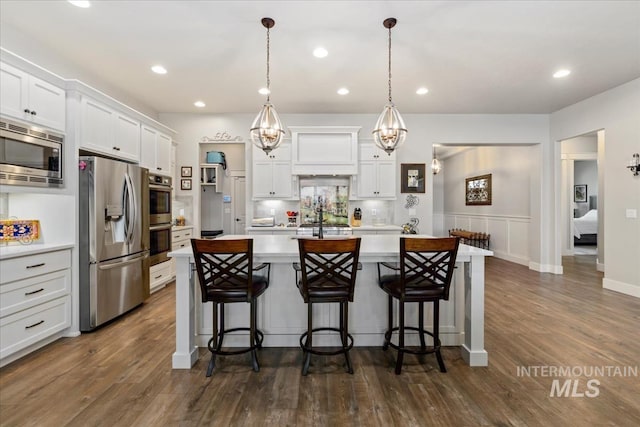 547 S Rivermist Ave, Star, ID 83669 - kitchen featuring stainless steel appliances, light countertops, white cabinets, a breakfast bar, and recessed lighting