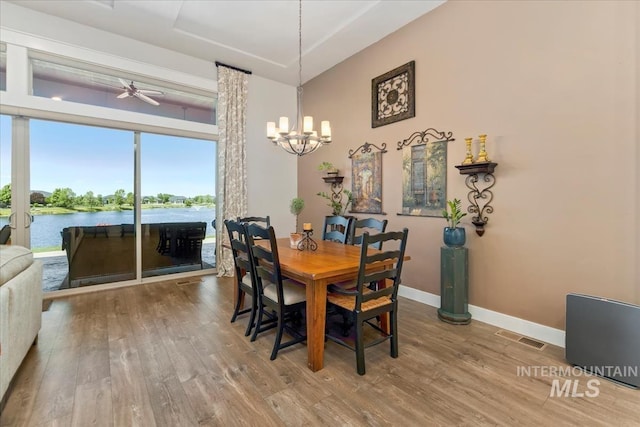 547 S Rivermist Ave, Star, ID 83669 - dining room featuring wood finished floors, a chandelier, a ceiling fan, and a water view