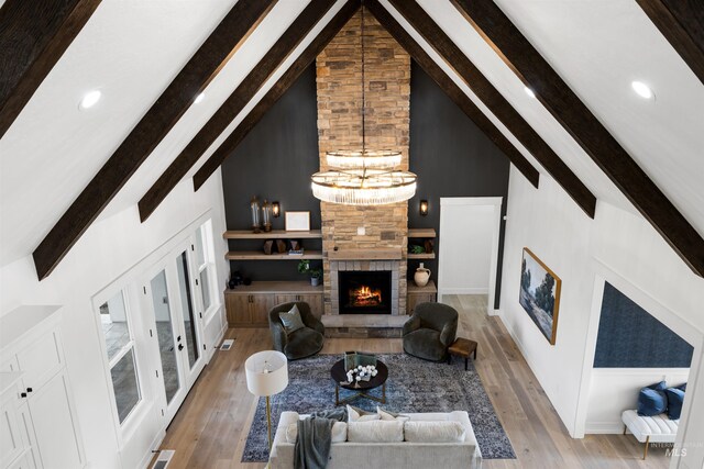 living area with recessed lighting, high vaulted ceiling, beamed ceiling, wood finished floors, and a fireplace