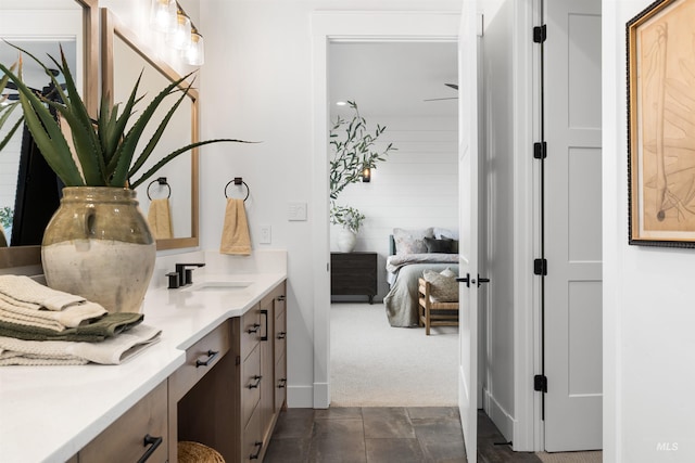 ensuite bathroom with ensuite bath, vanity, and baseboards