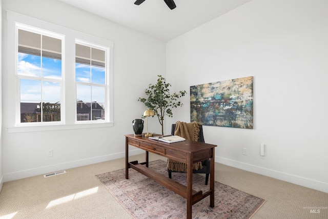 carpeted home office featuring baseboards, visible vents, and ceiling fan