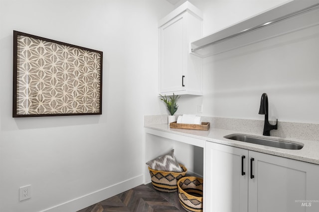 laundry area with baseboards and a sink
