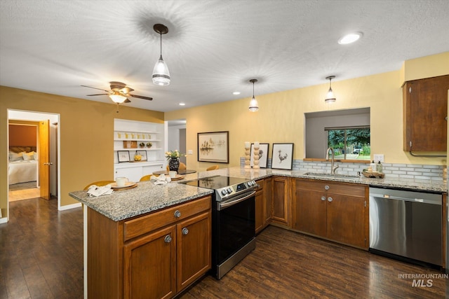 222 Dawn St, Eagle, ID 83616 - kitchen featuring appliances with stainless steel finishes, dark wood-type flooring, tasteful backsplash, a peninsula, and recessed lighting