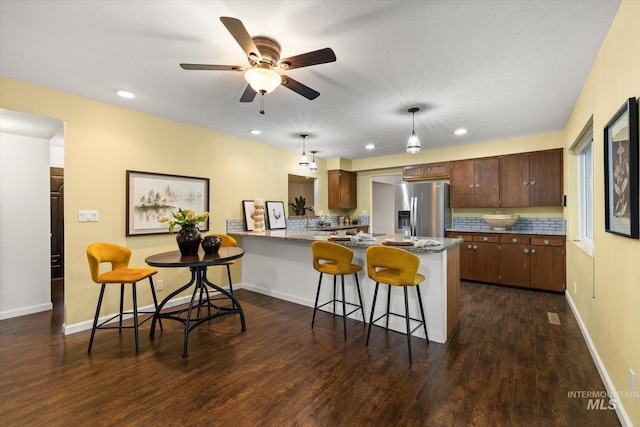 222 Dawn St, Eagle, ID 83616 - kitchen featuring stainless steel fridge with ice dispenser, a peninsula, a kitchen bar, dark wood-style flooring, and ceiling fan