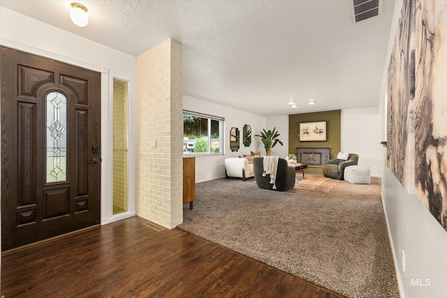 222 Dawn St, Eagle, ID 83616 - entrance foyer with dark wood-style floors, a fireplace, dark colored carpet, and a textured ceiling