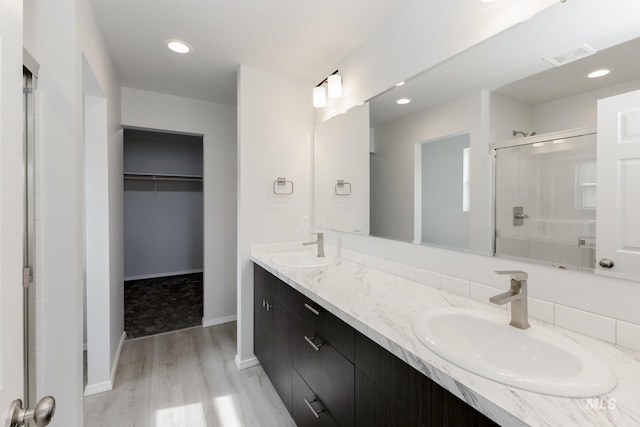 3937 W Tribute St, Meridian, ID 83642 - bathroom with a stall shower, visible vents, a sink, wood finished floors, and a spacious closet