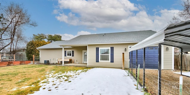 back of property with cooling unit, a yard, a garage, and a carport