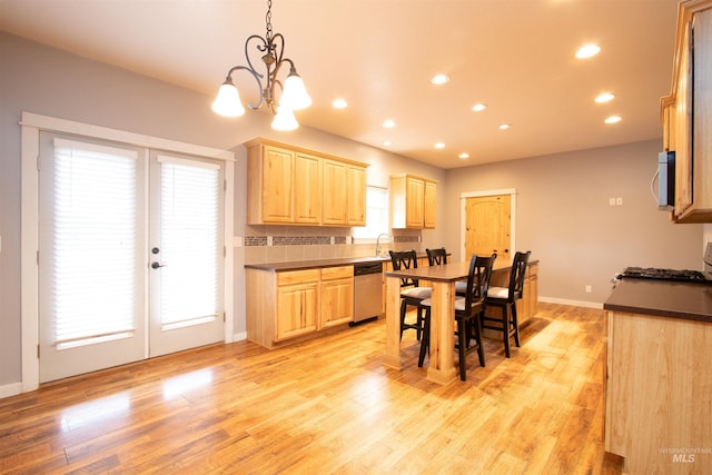 kitchen featuring appliances with stainless steel finishes, decorative light fixtures, light hardwood / wood-style floors, and light brown cabinetry