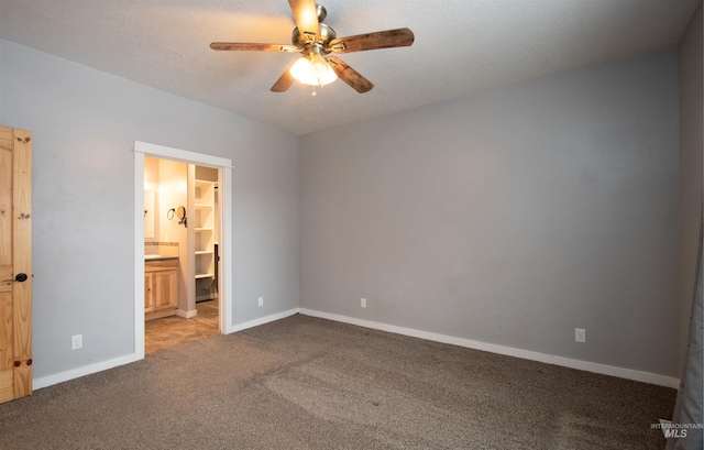 unfurnished bedroom with light carpet, ensuite bathroom, and ceiling fan