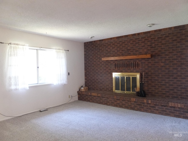 unfurnished living room with carpet floors, a textured ceiling, and a fireplace
