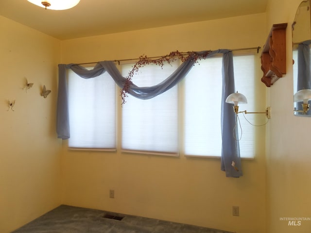 unfurnished dining area with visible vents, plenty of natural light, and carpet floors