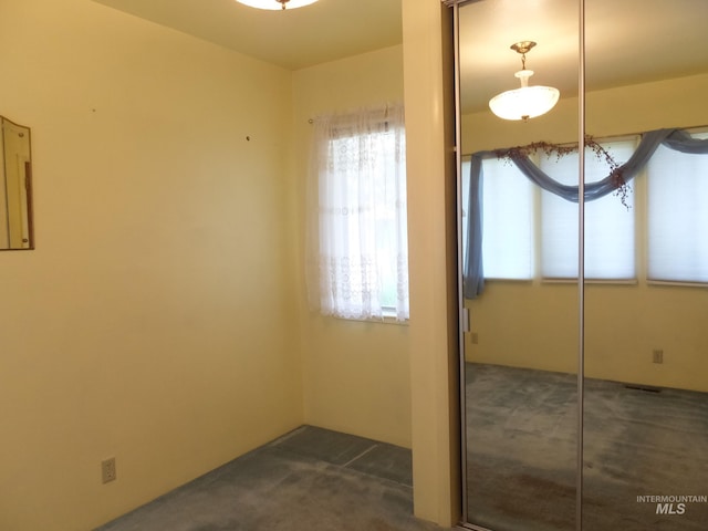unfurnished bedroom featuring a closet and dark colored carpet