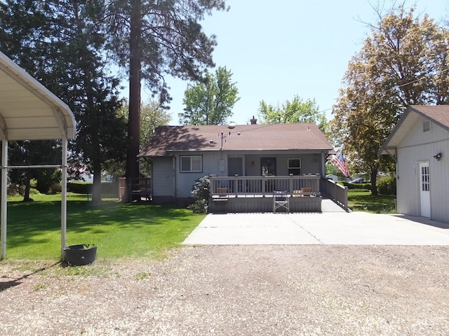 rear view of property featuring a lawn and roof with shingles