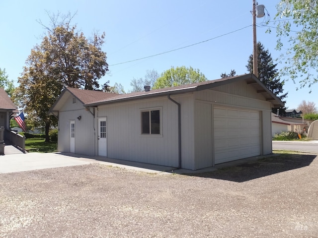 detached garage featuring dirt driveway