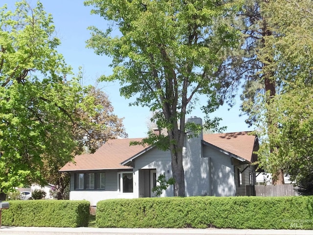 view of home's exterior with fence and a chimney