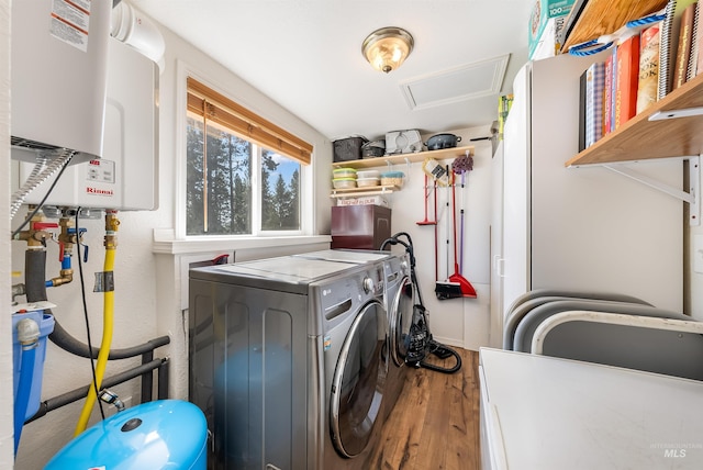 washroom featuring hardwood / wood-style flooring, washer and dryer, and water heater