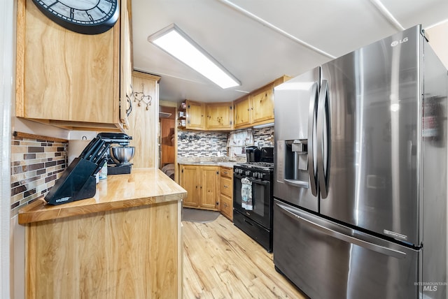 kitchen with light wood-type flooring, butcher block counters, stainless steel refrigerator with ice dispenser, tasteful backsplash, and gas stove