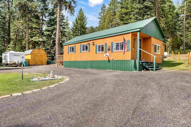 view of front of property featuring a shed