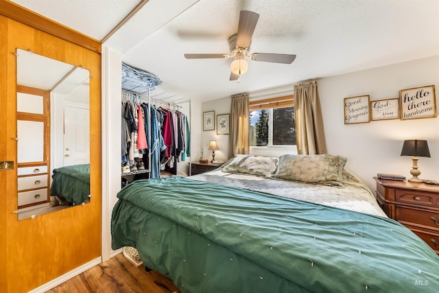 bedroom featuring ceiling fan, dark wood-type flooring, a closet, and a textured ceiling