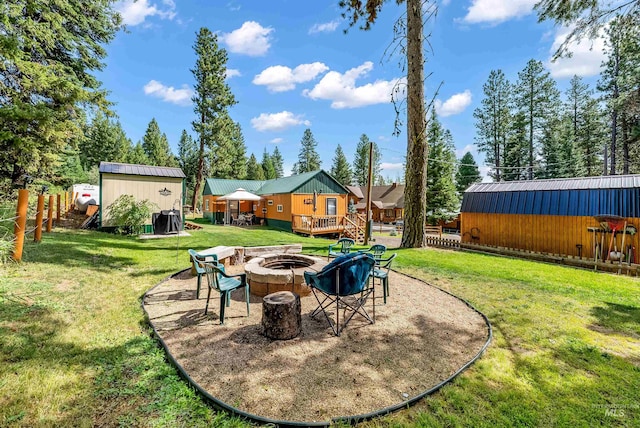 view of yard with a deck, an outdoor fire pit, and an outdoor structure