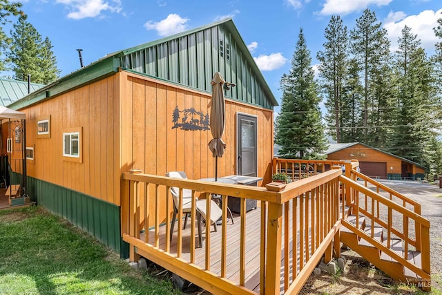 exterior space with a garage, an outbuilding, and a wooden deck