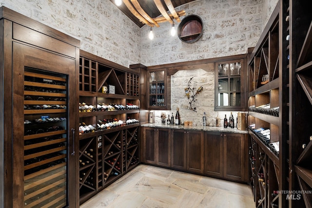 1358 N Morehouse Ave, Eagle, ID 83616 - wine room with wallpapered walls, wine cooler, light stone finish flooring, a high ceiling, and bar