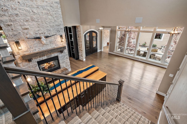 1358 N Morehouse Ave, Eagle, ID 83616 - stairway featuring wood finished floors, baseboards, a stone fireplace, a chandelier, and a high ceiling