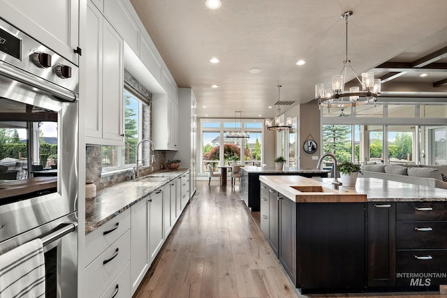 1358 N Morehouse Ave, Eagle, ID 83616 - kitchen with a chandelier, a sink, stainless steel double oven, butcher block counters, and recessed lighting
