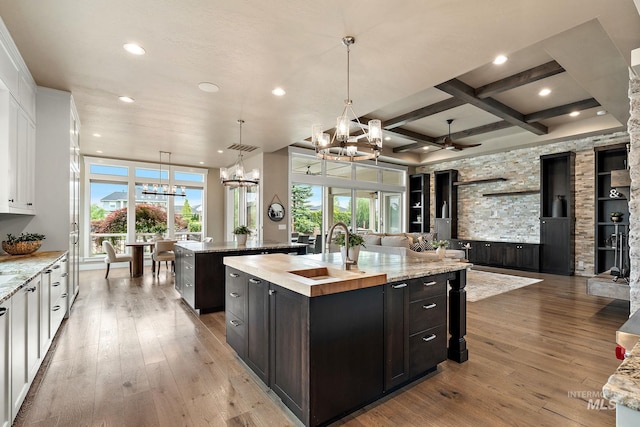 1358 N Morehouse Ave, Eagle, ID 83616 - kitchen featuring a chandelier, a large island with sink, a sink, white cabinetry, and healthy amount of natural light