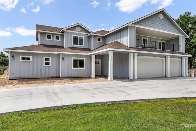 view of front of property featuring a balcony, driveway, an attached garage, and board and batten siding