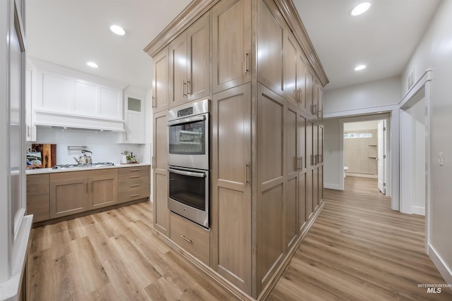 kitchen with appliances with stainless steel finishes, light wood-type flooring, light countertops, and recessed lighting