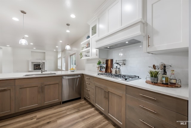 kitchen with stainless steel appliances, a sink, light countertops, and white cabinets