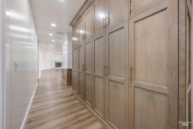 corridor featuring light wood-style floors, recessed lighting, visible vents, and baseboards